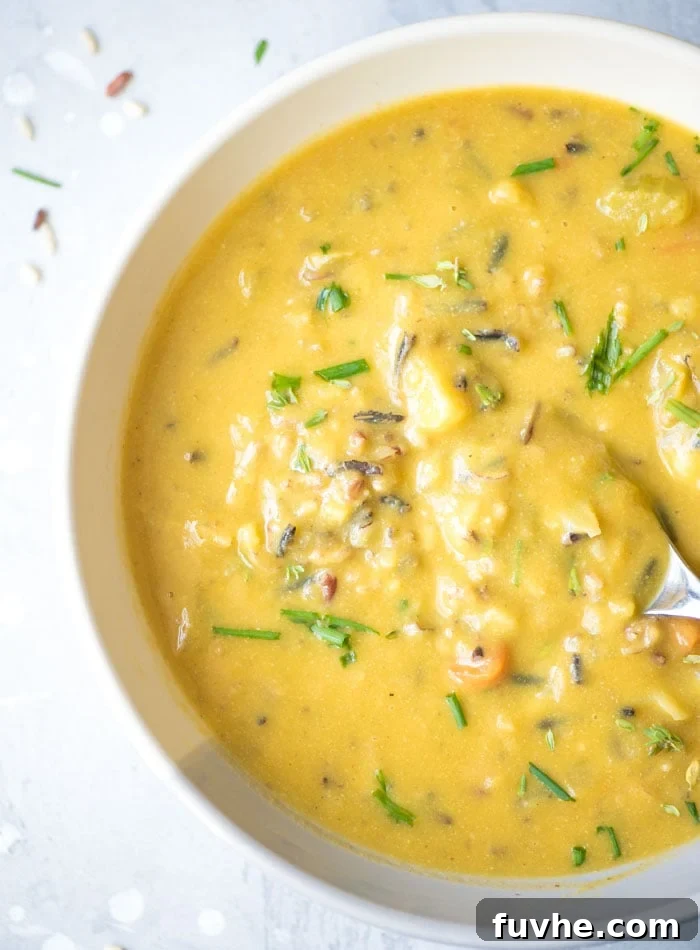 Bowl of creamy cauliflower wild rice soup topped with chopped chives.