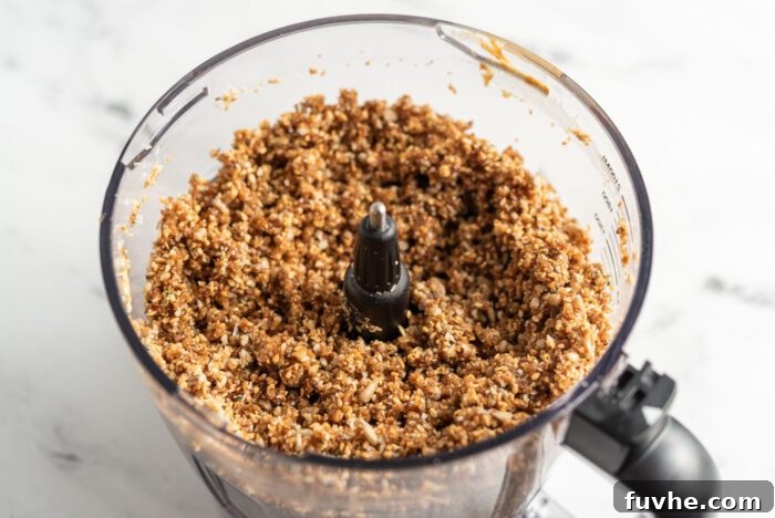 Sticky energy bar dough in a food processor, showing its cohesive texture.