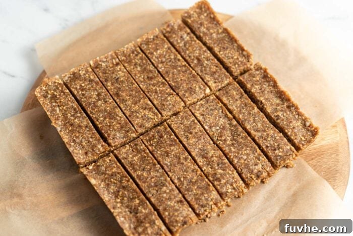Sliced energy bars arranged neatly on a parchment paper-lined round cutting board, showcasing their ready-to-eat state.