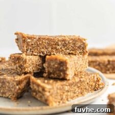 Close up of sesame and sunflower seed energy bars on a plate, showing texture and golden color.