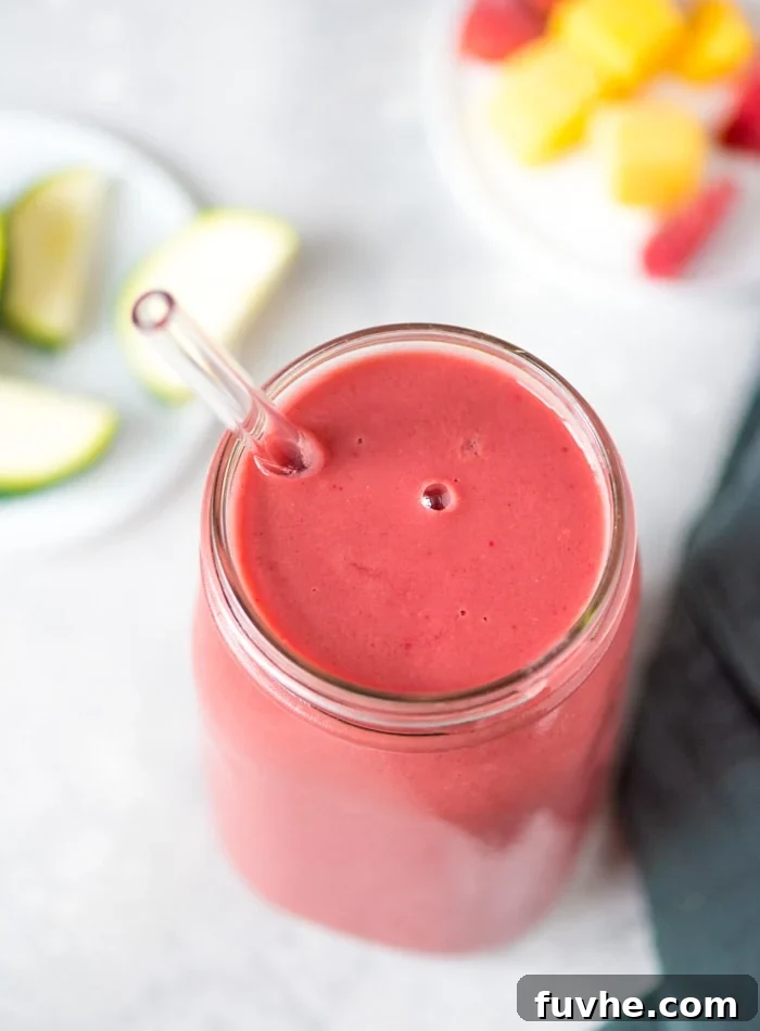 Close-up of a vegan strawberry mango smoothie with almond milk in a glass.