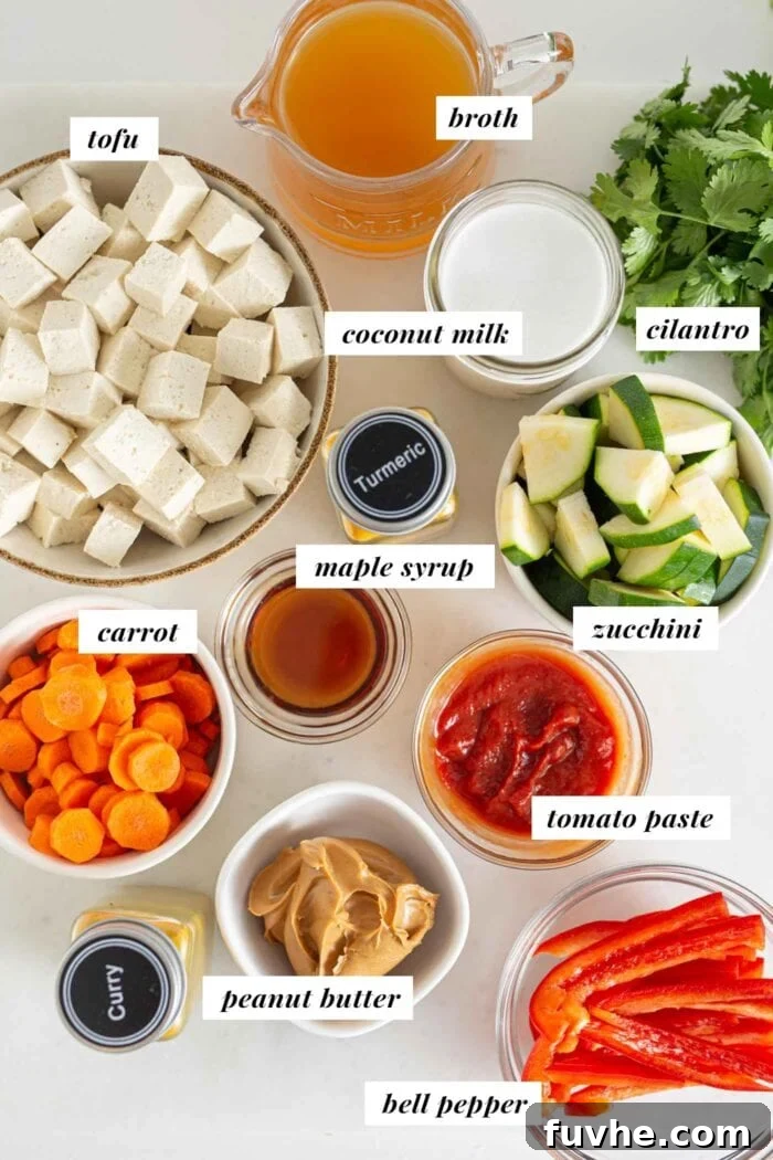 Creamy Vegan Panang Tofu Curry 3 Labeled ingredients for a vegetable panang curry in bowls on a counter top, showing fresh vegetables, spices, and sauces.