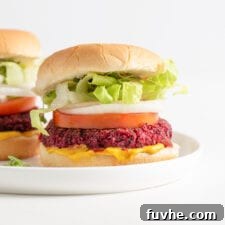 A close-up of a delicious vegan beet burger on a bun with fresh toppings, highlighting its texture and vibrant color.