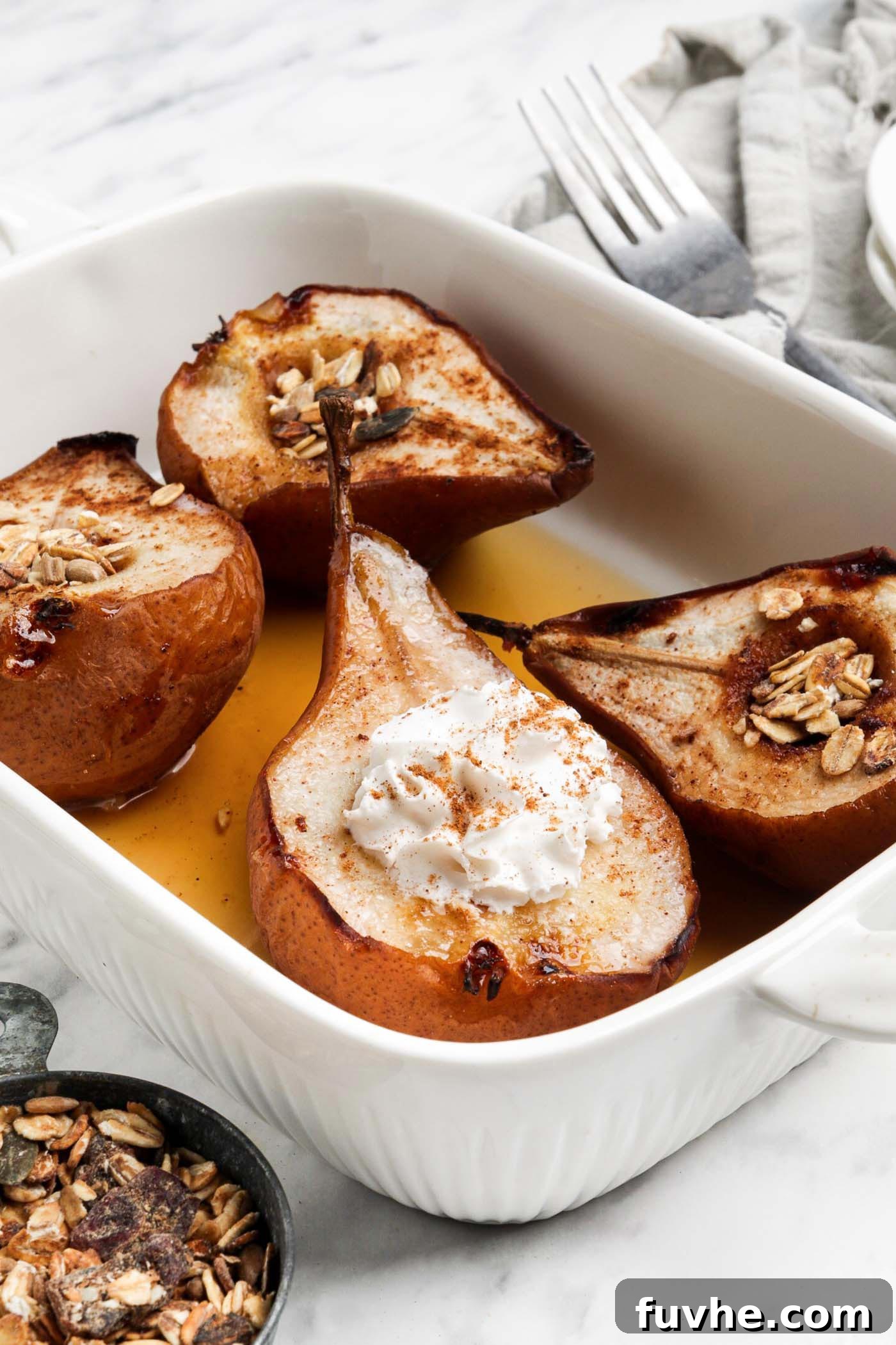 Warm Cinnamon Pear Delight 2 Four halves of glistening baked pears, drizzled with maple syrup and topped with fluffy whipped cream, resting in an elegant baking dish.