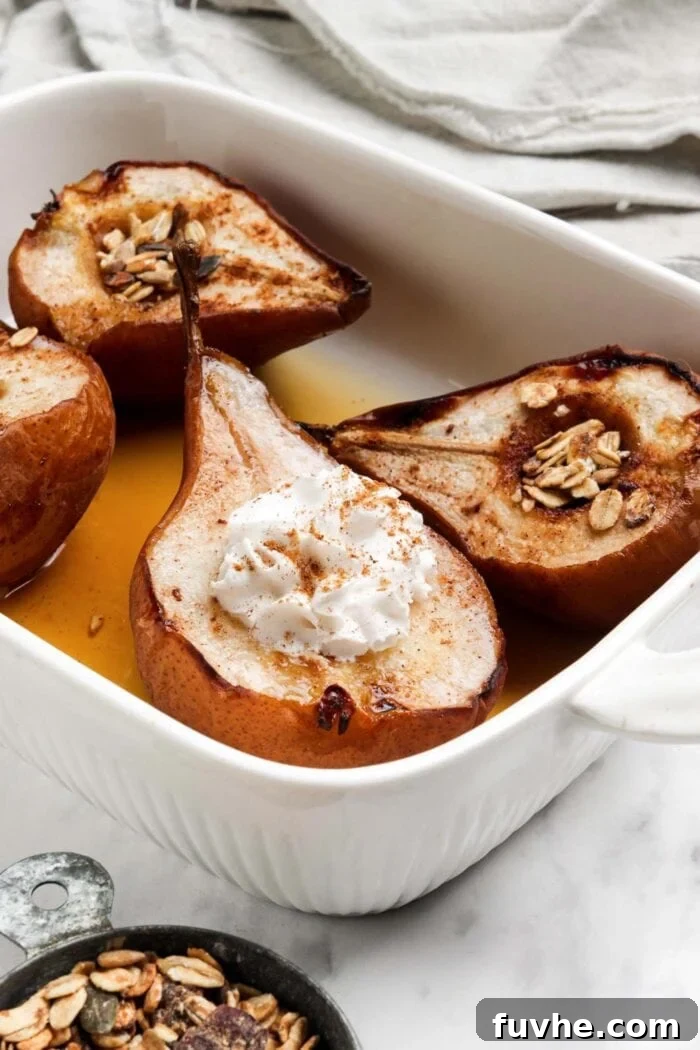 Warm Cinnamon Pear Delight 7 Four halves of exquisitely baked pears, lovingly topped with maple syrup and a generous swirl of whipped cream, presented in a ceramic baking dish.