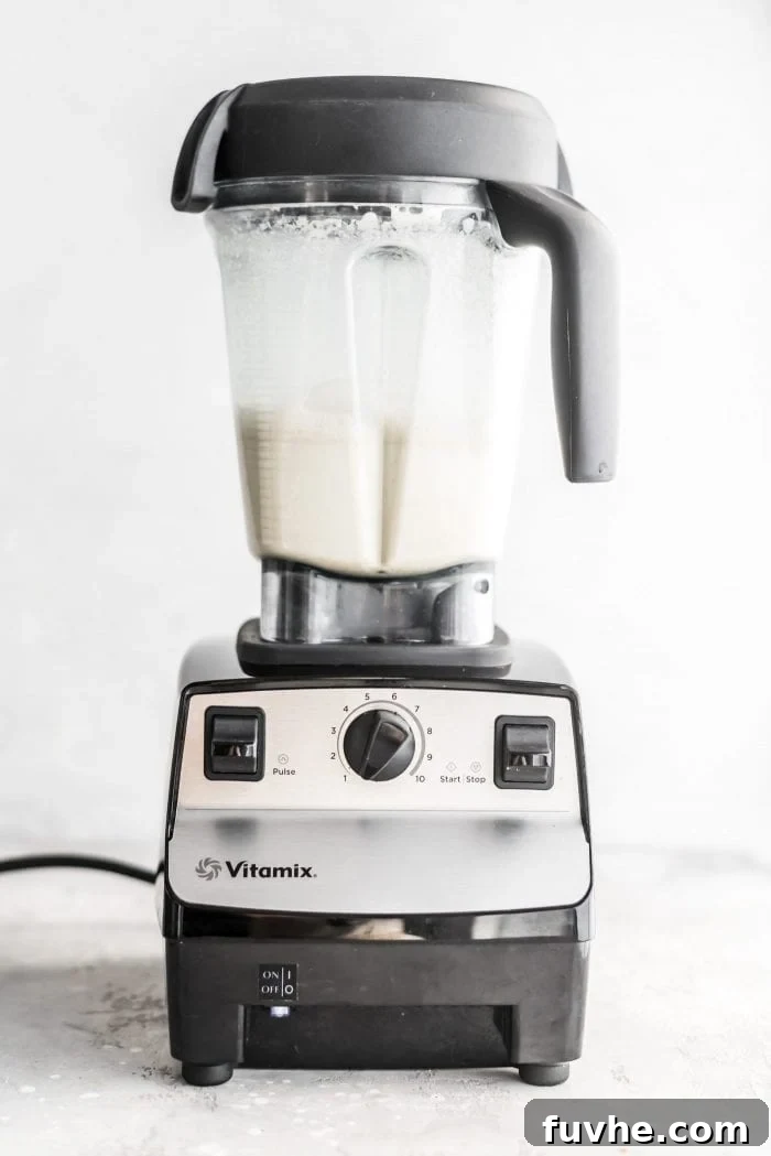 Perfectly blended oat milk mixture in a Vitamix, smooth and ready for straining.