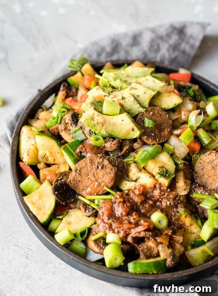 Plant-Powered Breakfast Skillet 4 A cooking scene showing the various ingredients of the vegan breakfast skillet being sautéed in a large pan, demonstrating the cooking process.
