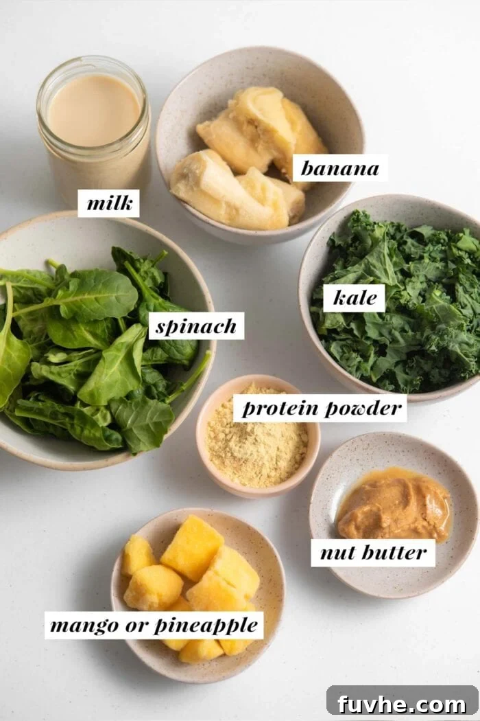 Kale and Apple Detox Smoothie 3 A beautifully arranged selection of fresh ingredients for a green kale smoothie, including kale, spinach, banana, mango, protein powder, and almond milk.