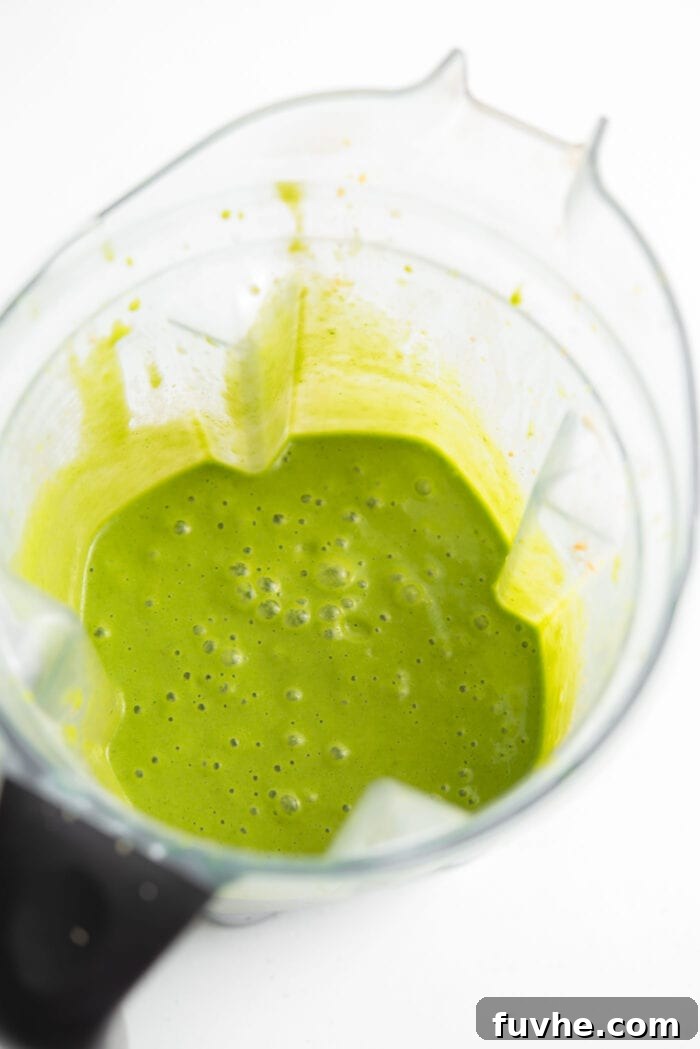 Kale and Apple Detox Smoothie 4 A vibrant green kale spinach smoothie blending smoothly in a high-speed blender, showcasing its creamy texture.