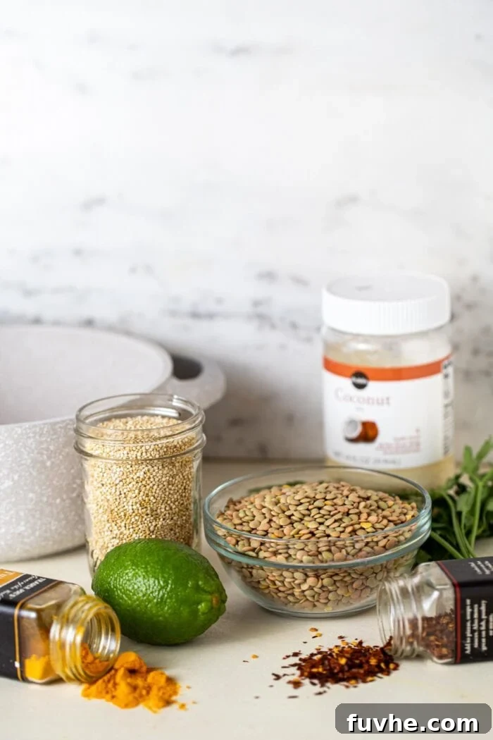 A bowl of lentils, container of quinoa, a lime and a few containers of spices sitting on a counter top.
