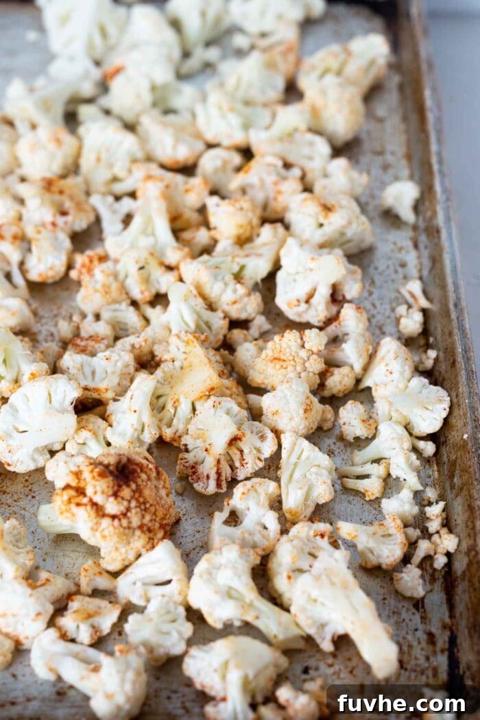 Mediterranean Cauliflower Power Bowls 3 Chopped cauliflower on a parchment paper lined baking tray.