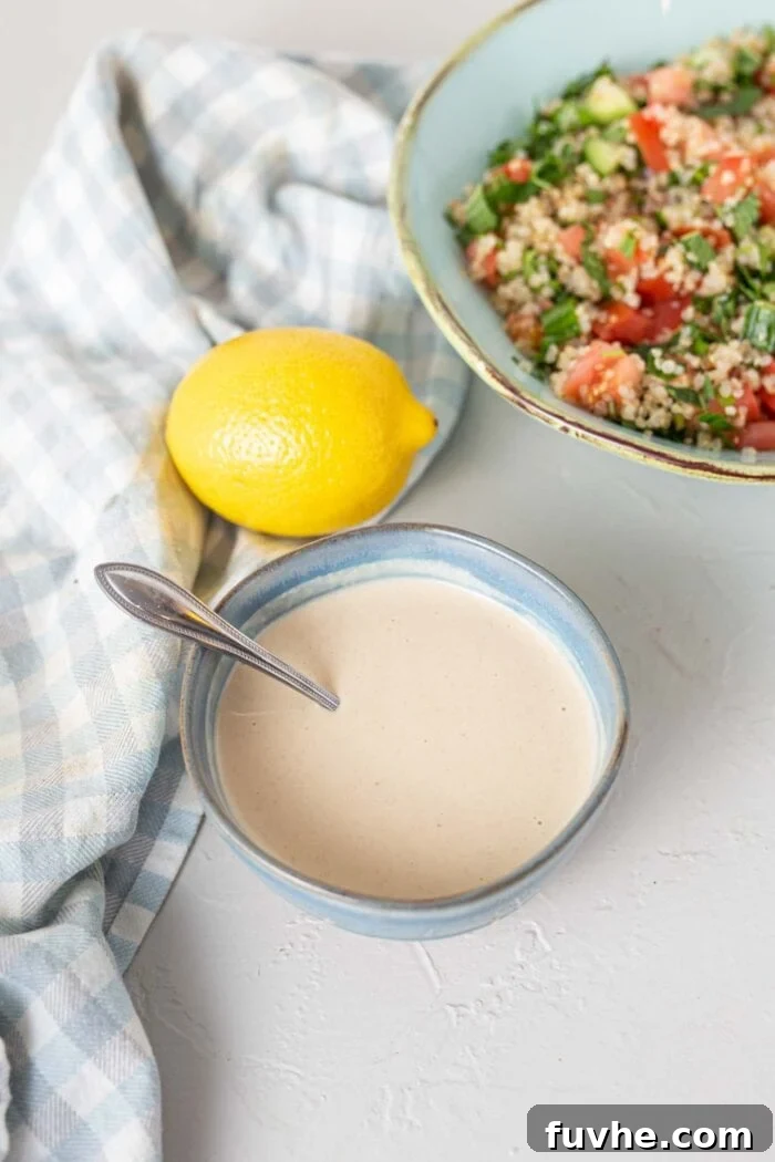 Mediterranean Cauliflower Power Bowls 5 Creamy tahini sauce in a small dish with a spoon.