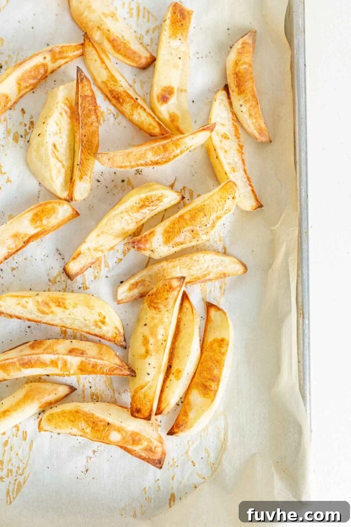 Ultimate Vegan Chili Cheese Fries 4 Baked fries on a baking tray lined with parchment paper, perfectly golden and crispy.