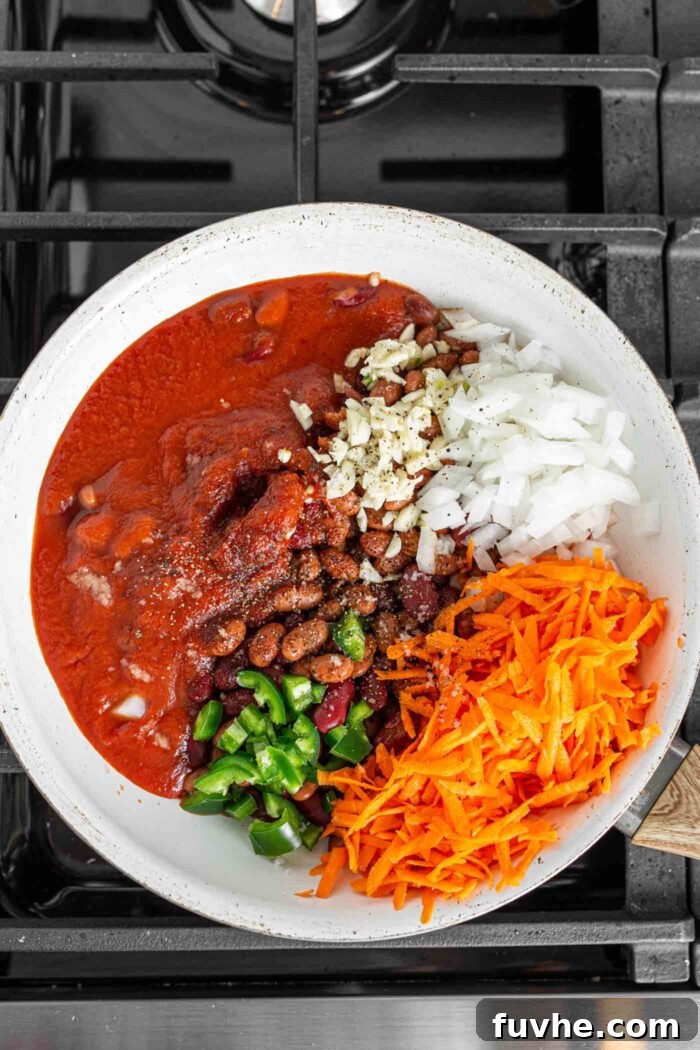 Ultimate Vegan Chili Cheese Fries 5 Tomato sauce, green pepper, onion, carrot and beans in a skillet before cooking.