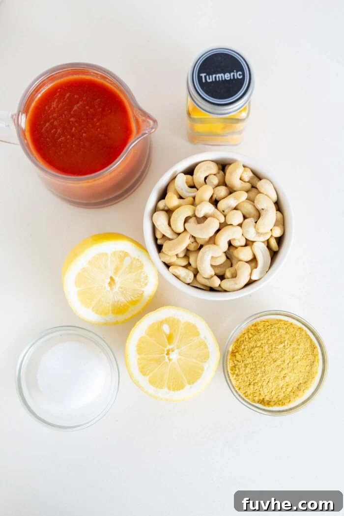 Ultimate Vegan Chili Cheese Fries 7 Raw cashews, nutritional yeast, lemon, and tomato sauce in containers on a counter, ready for queso.