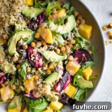 A plate of quinoa avocado salad with beets, squash and mustard dressing.