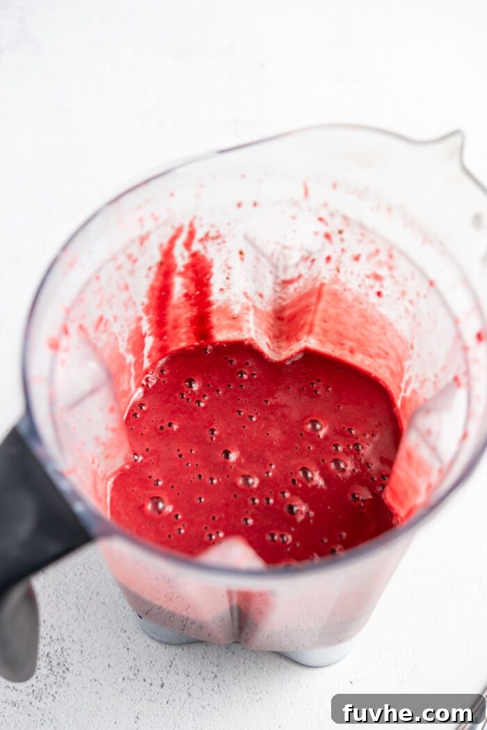 Creamy blended beet orange smoothie visible inside a high-speed blender.