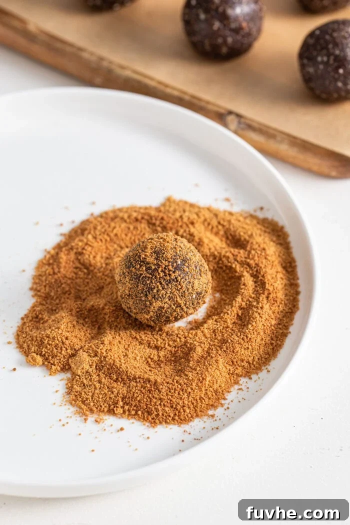 Chocolate energy ball rolled in coconut sugar on a plate.