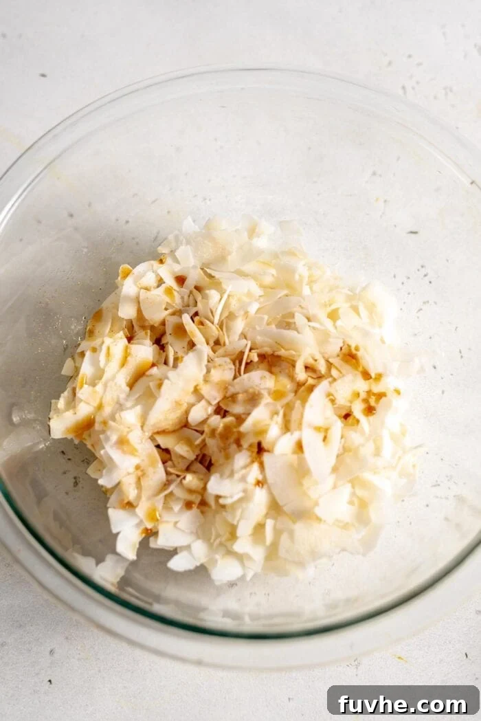 Smoky Coconut Crisps 4 A bowl of coconut flakes with a marinade poured over it.