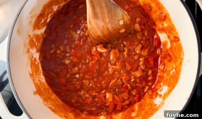Tomato sauce, mustard, maple syrup, Worcestershire sauce, and broth added to the pan and stirred, forming the base of the sloppy joe sauce.