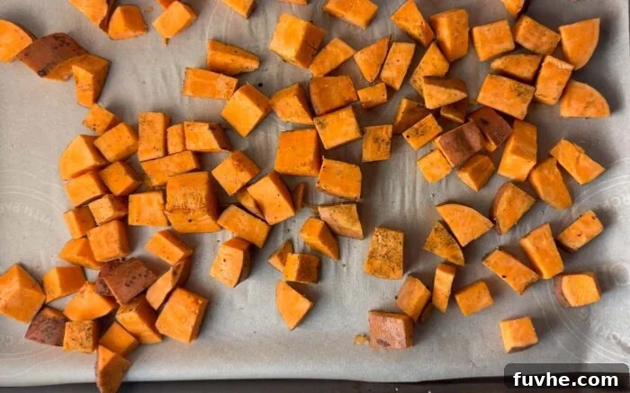 Cubed sweet potato on a baking sheet lined with parchment paper.