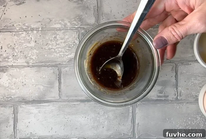 Balsamic dressing in a glass bowl with a spoon.