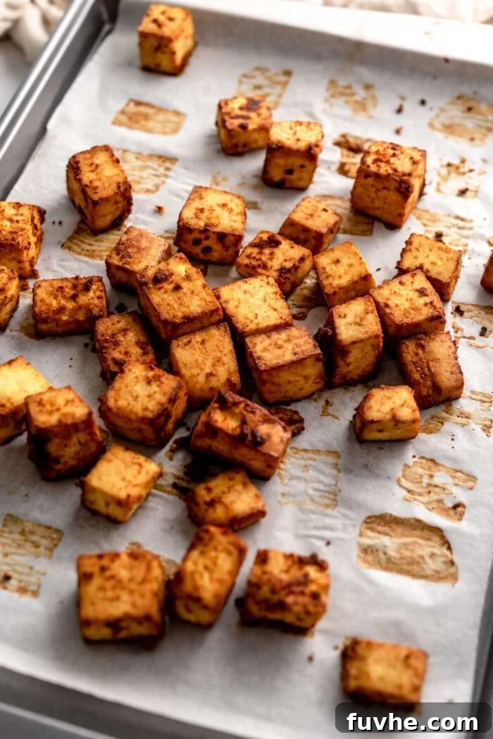 Cubes of spicy baked tofu on a baking pan.