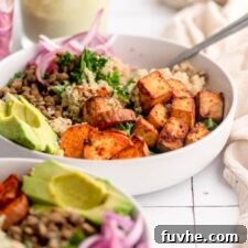 A colourful, healthy bowl with quinoa, tofu, sweet potato, lentils, avocado and kale.