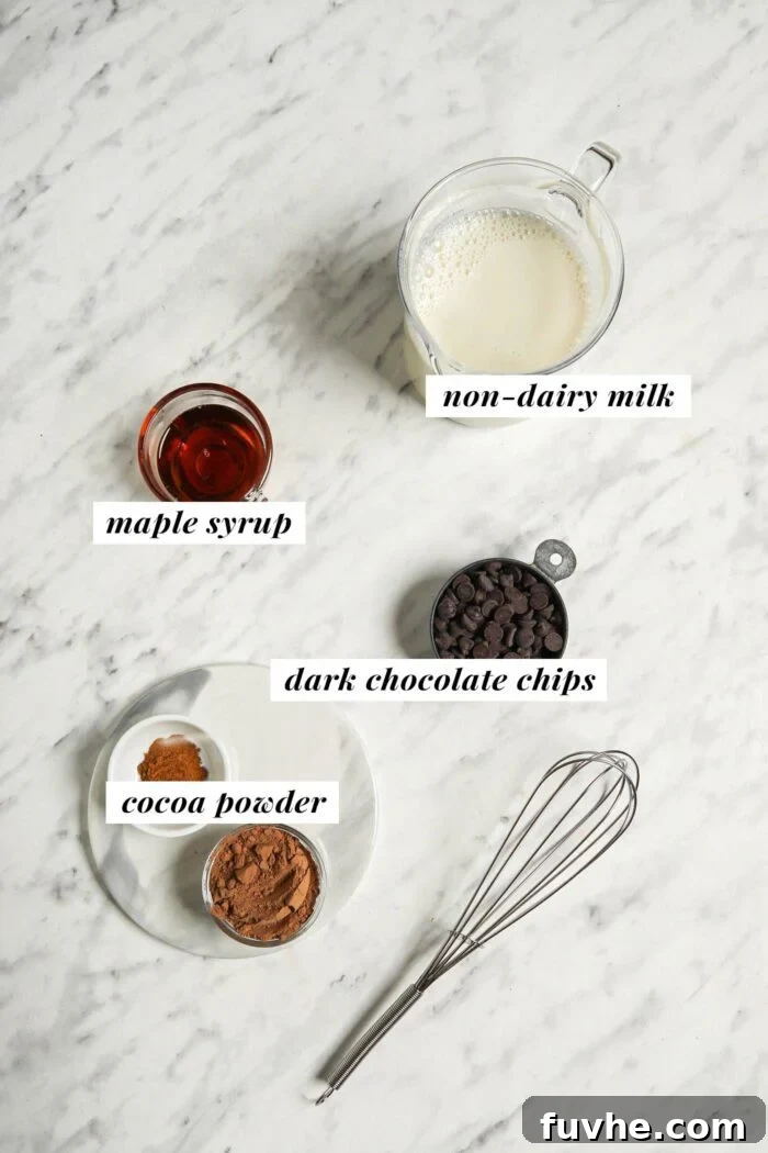Decadent Plant-Based Hot Chocolate 3 Maple syrup, milk, chocolate chips and cocoa powder in bowls on a marble counter.