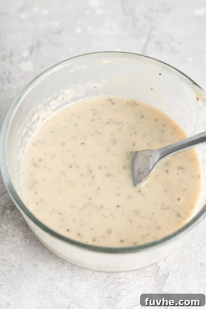 Smoky Vegan BBQ Chickpea Salad 5 Tahini ranch dressing mixed up in a small glass bowl with a fork resting in it.