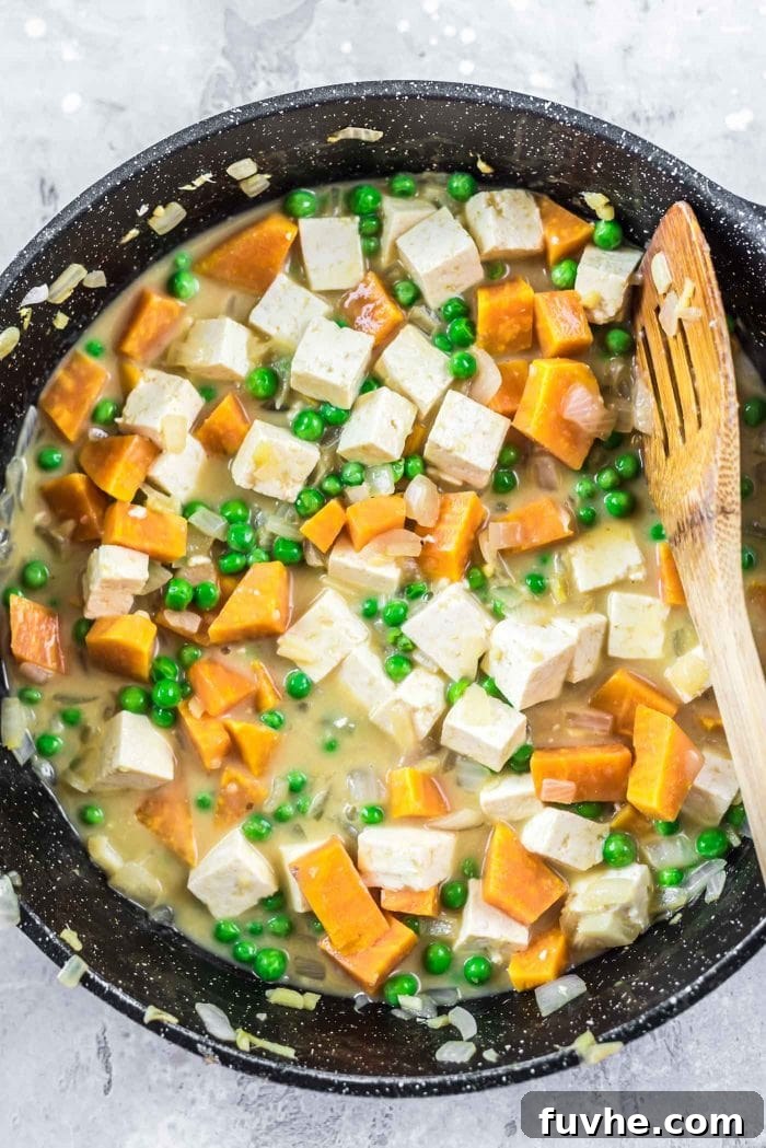 Sweet potato curry being cooked in a black saucepan.