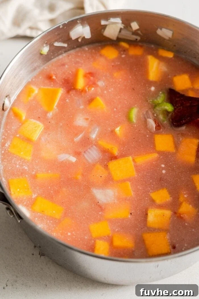 Golden Butternut Lentil Nourishment 6 Uncooked butternut squash, red lentils, diced tomatoes, and vegetable broth simmering in a large soup pot.