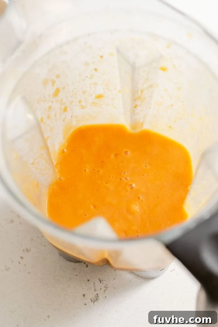 Golden Butternut Lentil Nourishment 7 Blended butternut squash lentil soup in a Vitamix container, showing its creamy texture.
