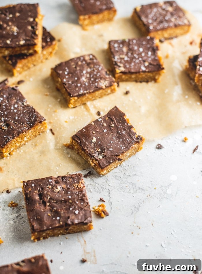 Wholesome Cashew Tahini Treats 7 A vibrant close-up of the finished vegan no-bake tahini cashew bars, showcasing the contrast between the chocolate and the light-colored base, ready to be enjoyed.