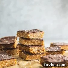 Wholesome Cashew Tahini Treats 8 Beautifully presented vegan no-bake cashew tahini bars with a generous chocolate coating, set on a clean background, ready to be enjoyed.