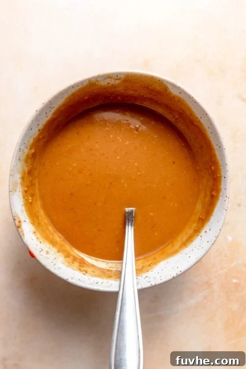 Peanut sauce in a small bowl with a spoon in it.
