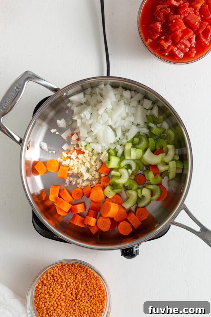 Hearty Curried Lentil Soup 4 Diced onion, carrots, celery, and minced garlic simmering in a skillet.