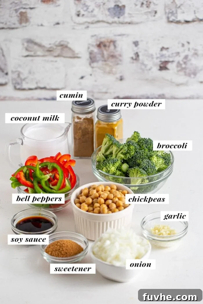 A flat lay image displaying all the essential ingredients laid out for making a quick chickpea and vegetable curry, clearly labelled for convenience.
