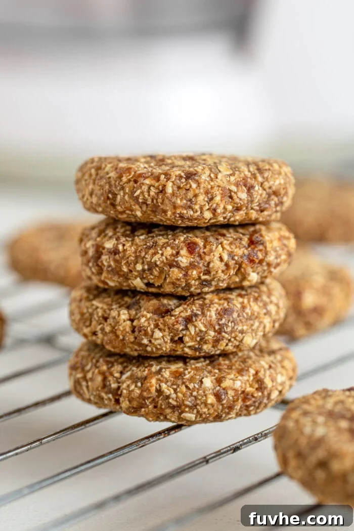 Stack of 4 tahini date cookies sitting on a cooling rack.