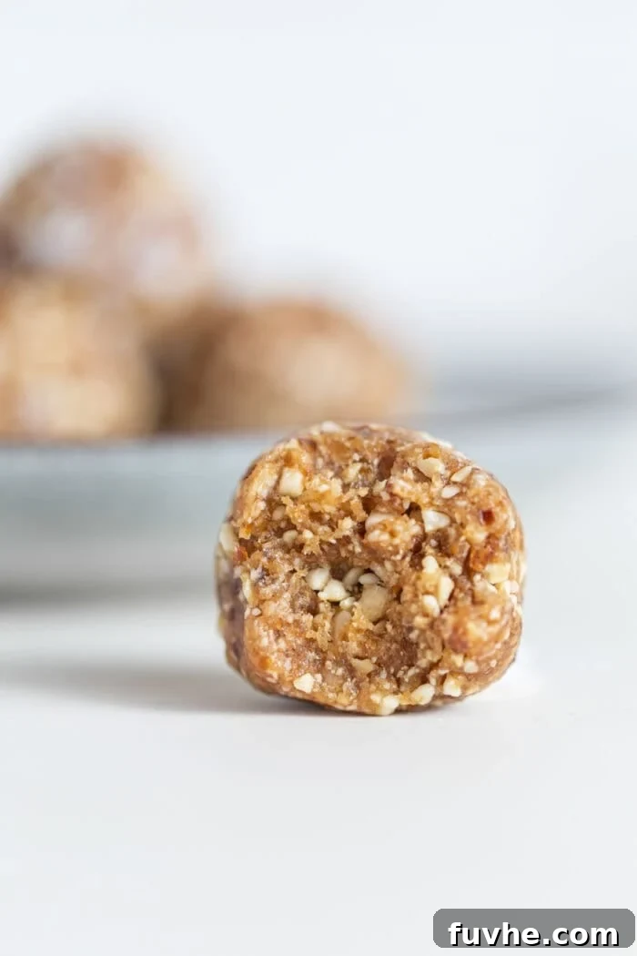 A raw energy ball with a bite taken out of it to show the texture on the inside.