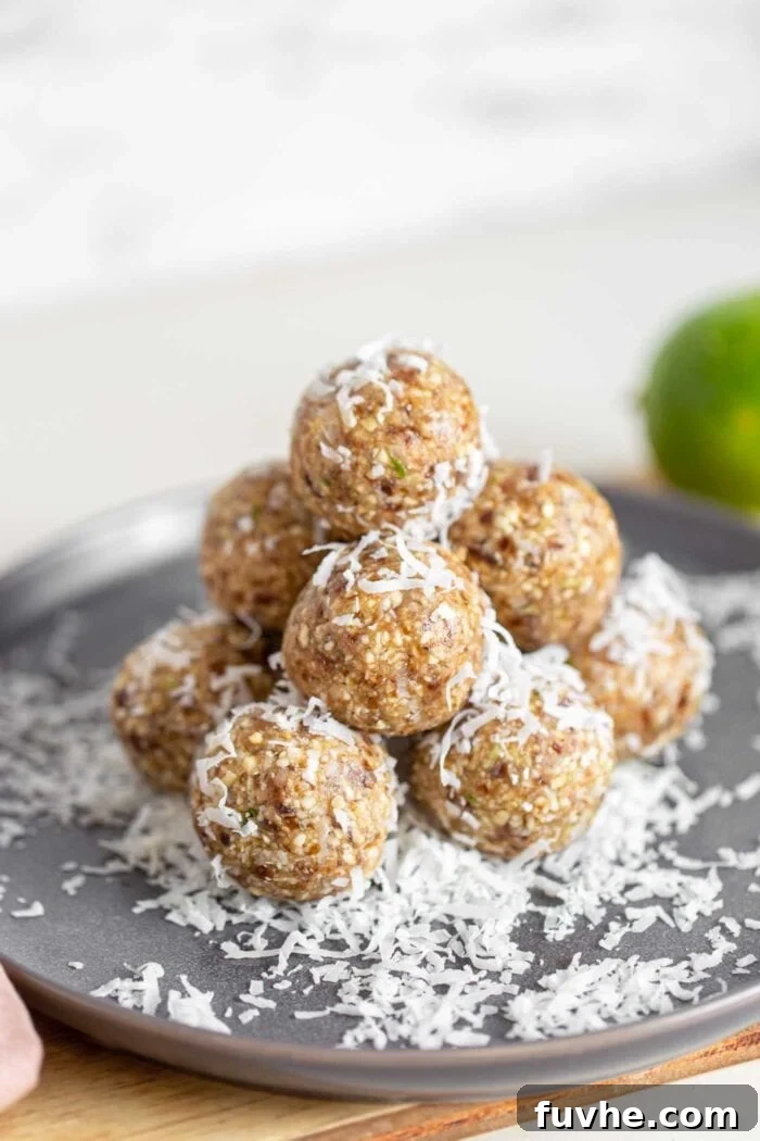 A stack of energy balls covered in shredded coconut on a plate.