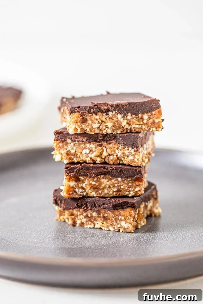 Stack of 4 chocolate coated cashew bars on a plate.