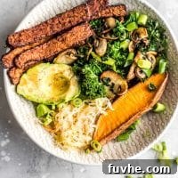 Overhead shot of a vegan tempeh bacon, avocado, kale and mushroom sweet potato breakfast bowl, presented beautifully for a balanced meal.