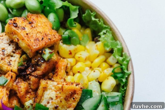 The Ultimate Vegan Macro Cheat Sheet 7 A vibrant and healthy bowl featuring tofu, fresh corn, and crisp lettuce, showcasing a balanced plant-based meal rich in protein.