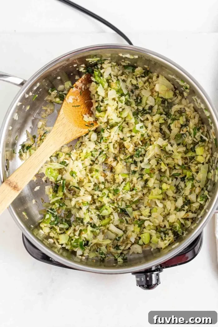 Wholesome Vegan Carb-Conscious Bowls 8 Cabbage, green onion, and cilantro actively sautéing in a hot skillet on a stovetop, browning beautifully.