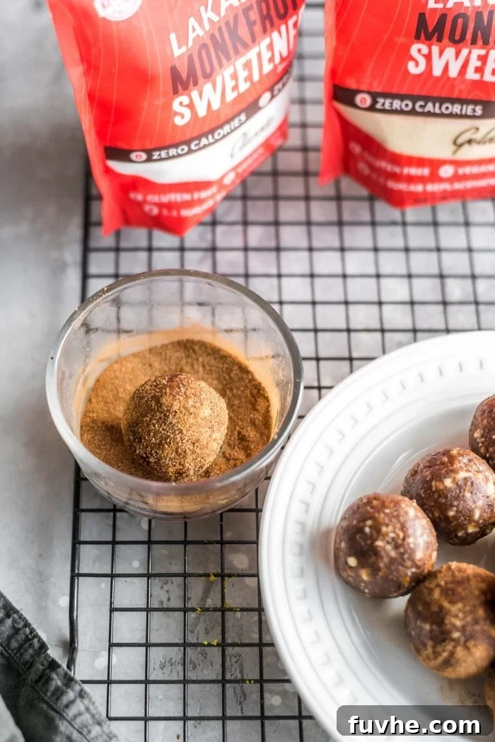 Cinnamon Sugar Bliss Bites 7 A hand rolling a cinnamon sugar ball into a dish of cinnamon sugar coating.