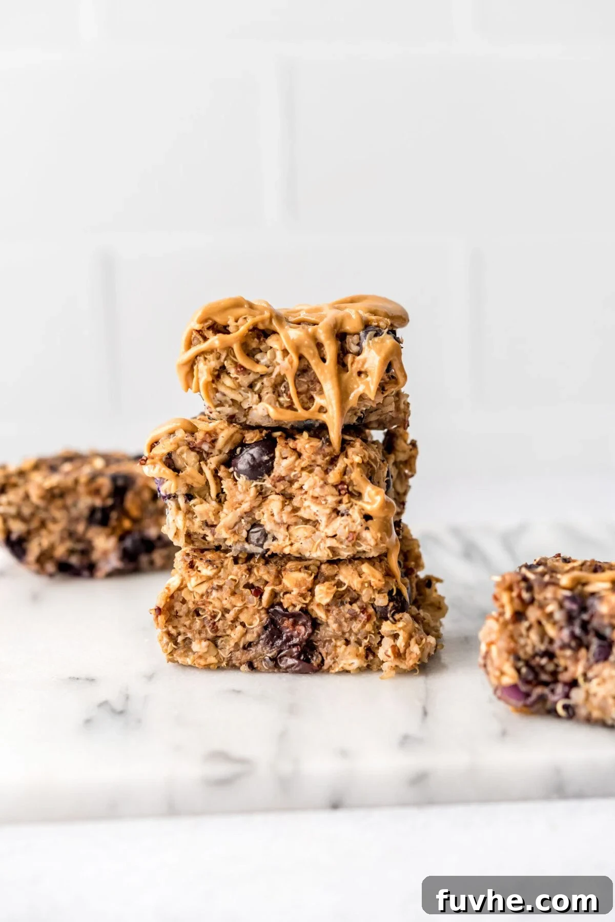 Snack Smarter: 31 Plant-Based Bites 2 Stack of 3 baked blueberry quinoa oatmeal bars drizzled with peanut butter.
