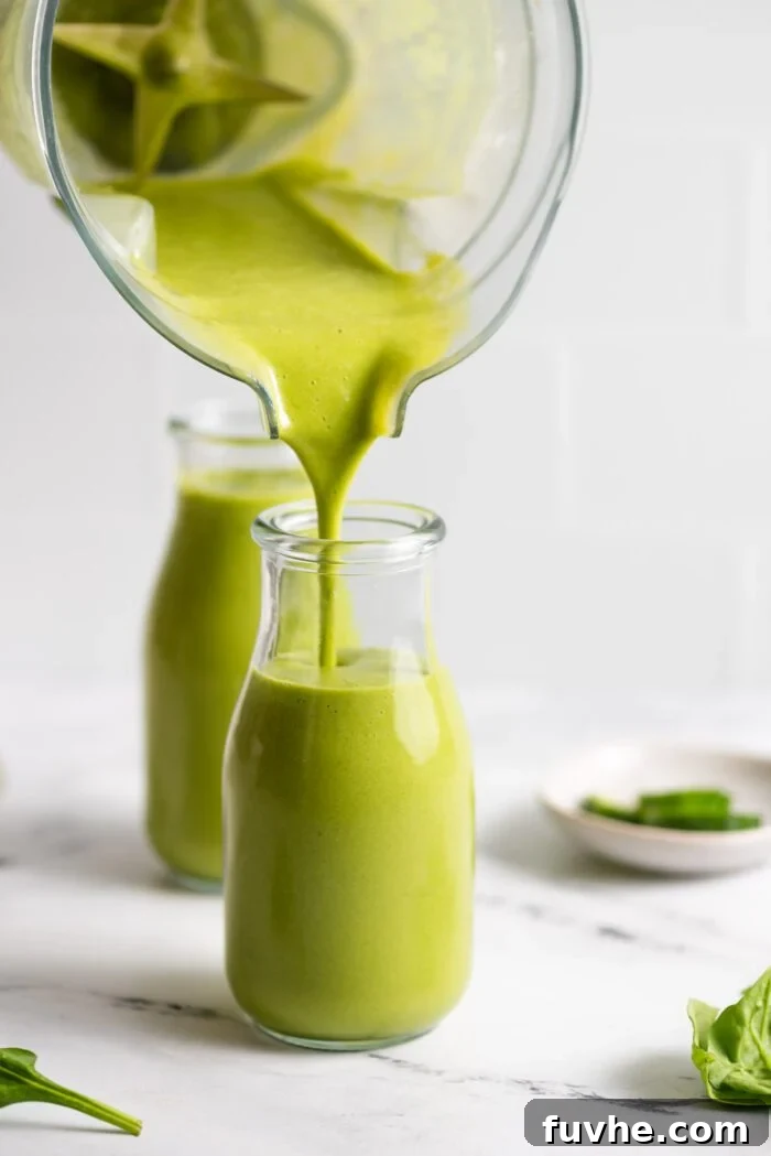Snack Smarter: 31 Plant-Based Bites 7 Pouring a green mango smoothie from a blender into a small jar.