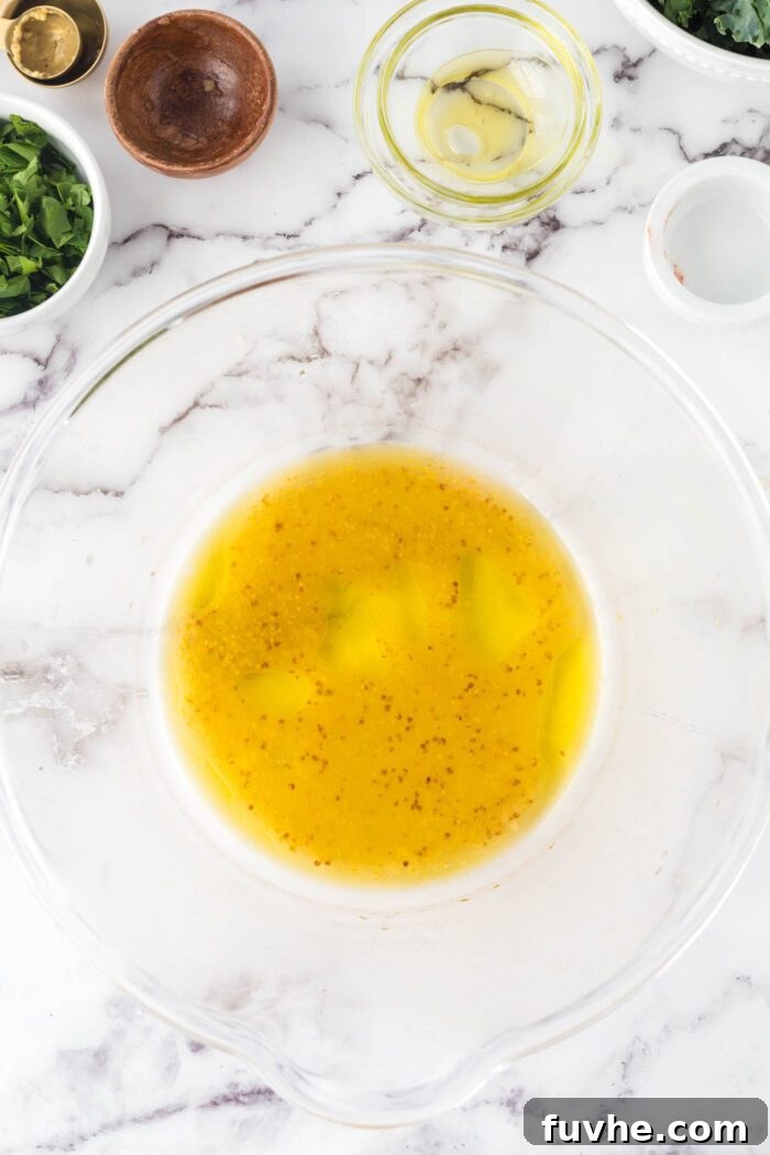 A zesty Dijon vinaigrette dressing freshly mixed in a large bowl, ready for the salad.