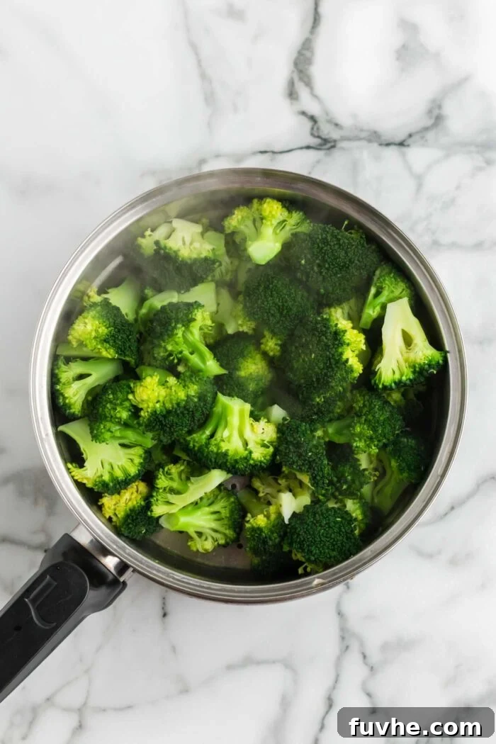 Steaming pot of freshly steamed broccoli florets on a marble surface, vibrant green and ready.